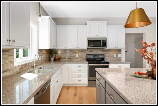 Tiled backsplash, solid surface counters, stainless steel appliance, and under-cabinet lighting level up the kitchen aesthetic