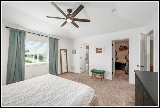 Primary suite overlooking the wetland preserve incudes a walk-in closet (door on the right) and a private bathroom (door on the left)