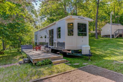 On this lot is a 2009 Park Model camper with a huge deck built up to it.