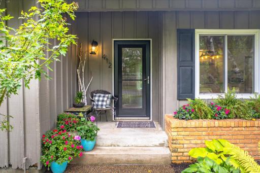 Cozy covered front porch protects from sun and rain