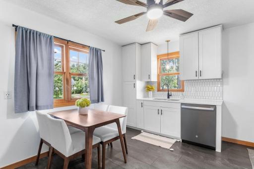 Modern, eat-in kitchen with sleek new shaker cabinets, granite countertops, stylist backsplash and tile flooring.