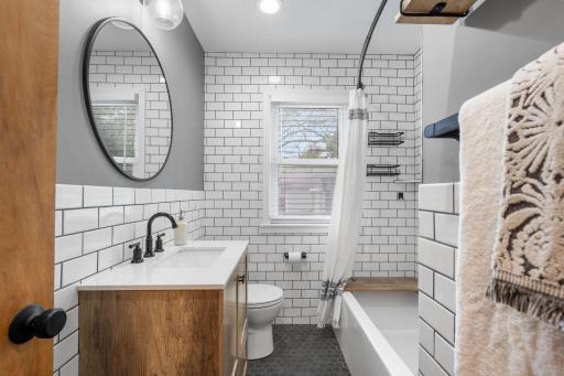 Completely updated main level full bathroom with new tub, new vanity, tile flooring, subway tile surround and contemporary fixtures & finishes.
