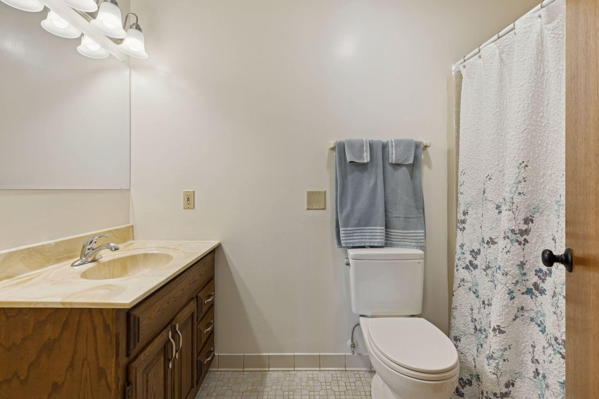 Main floor full bath with new toilet, lighting and hardware.