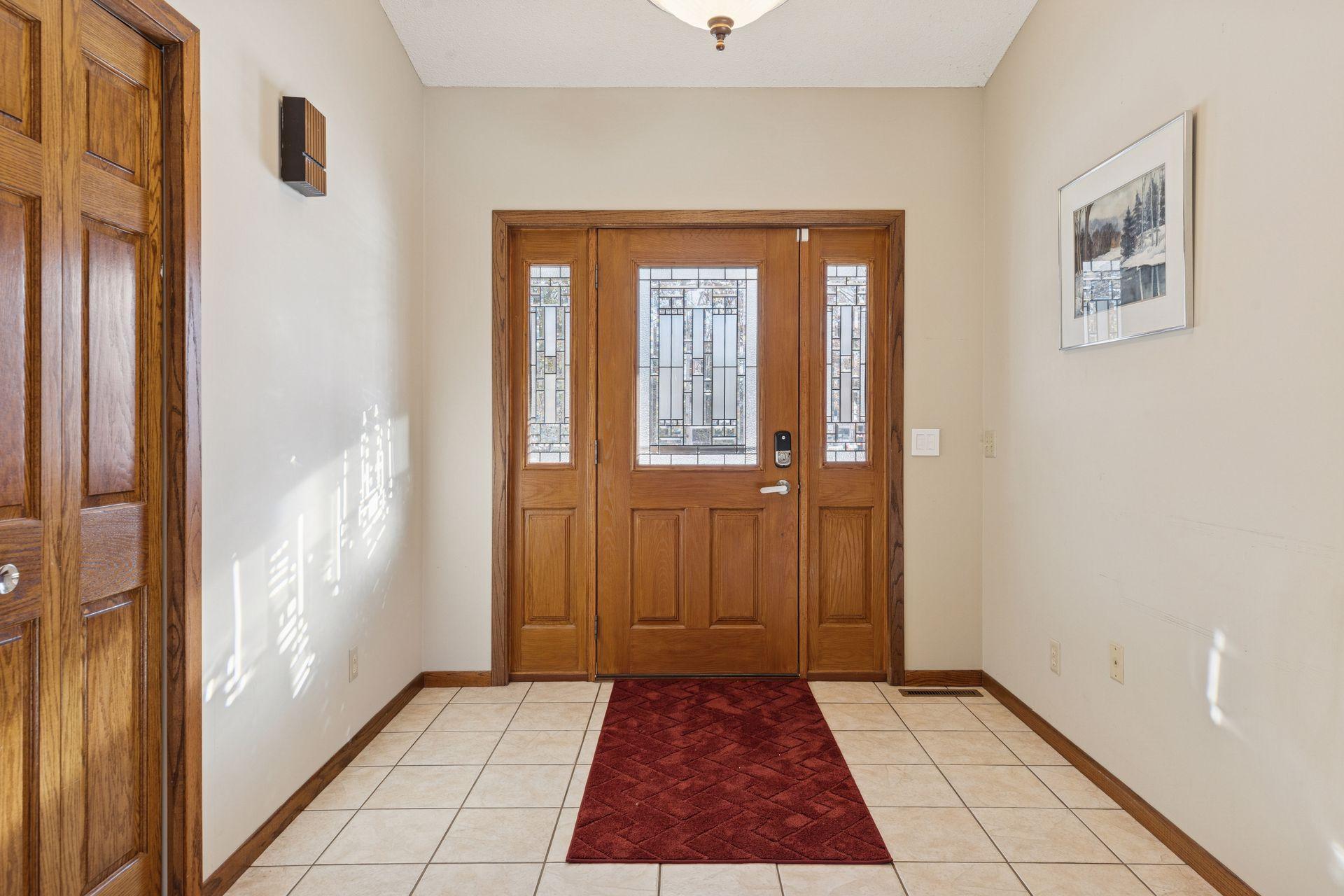 Spacious and vaulted foyer with ceramic tile flooring and coat closet.