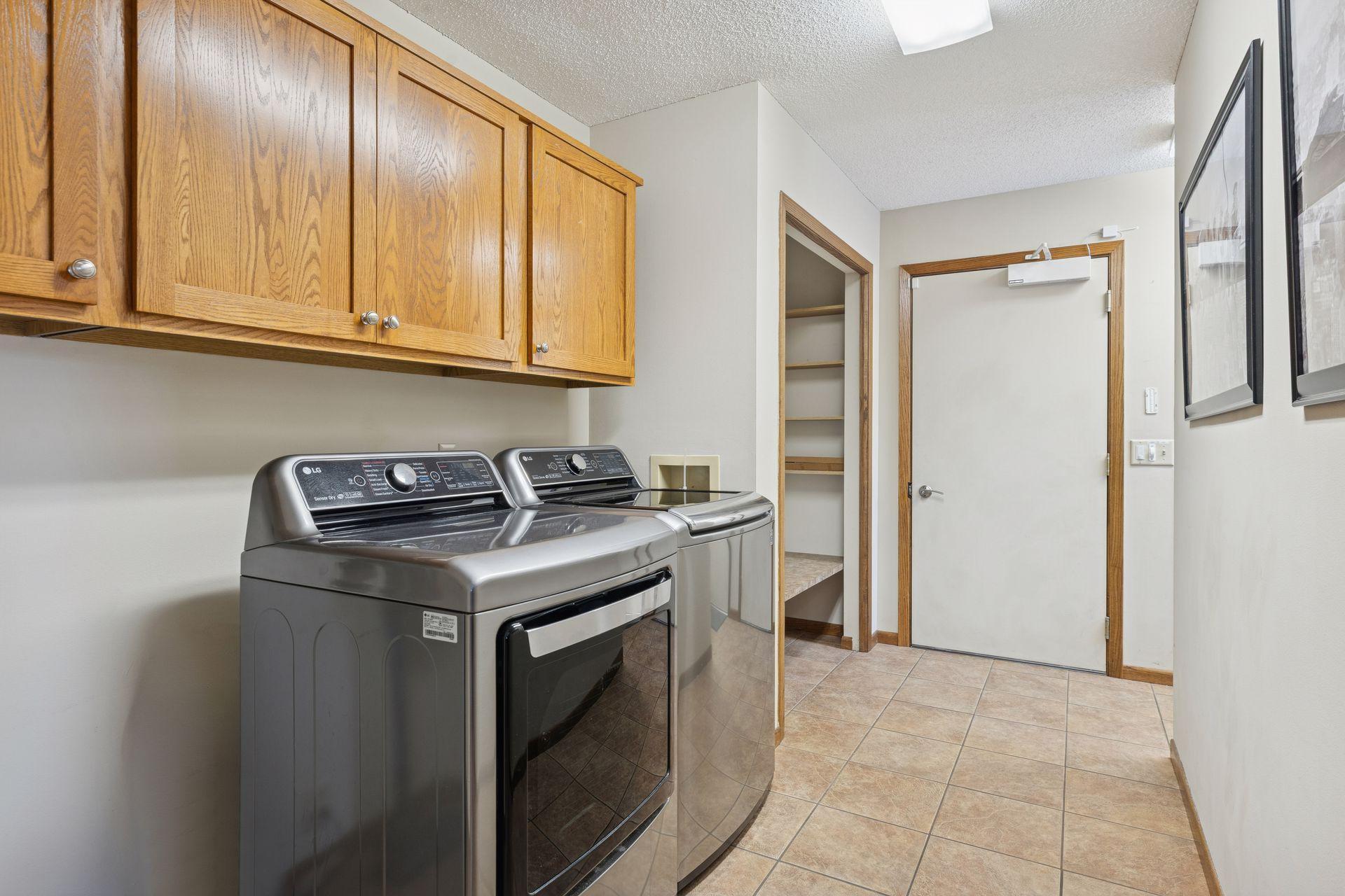 Main floor laundry room with cabinets and locker/coat closet.