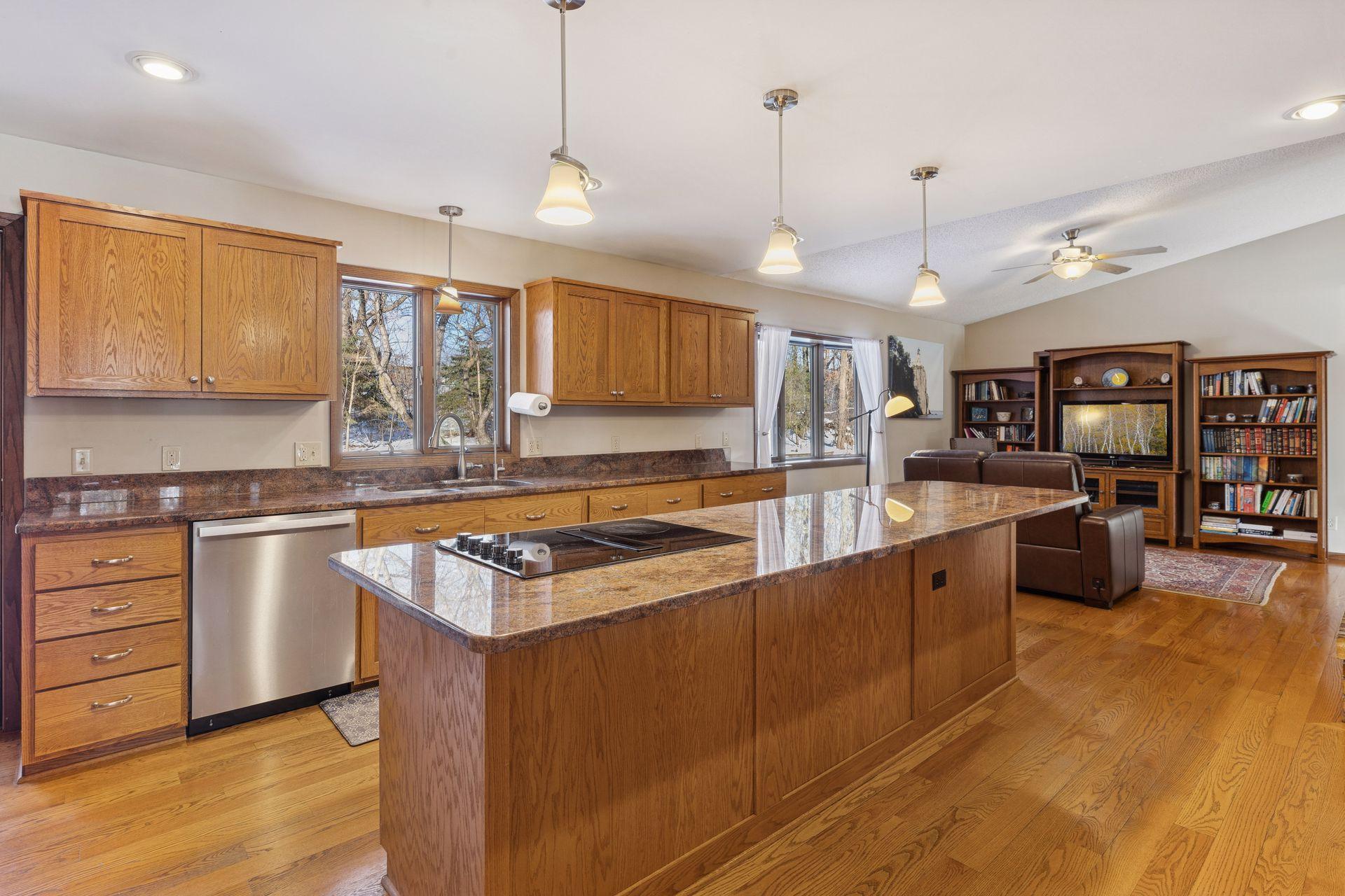 Large center island with built-in seating and Jen Air electric cooktop. Tons of cabinets and counter space.