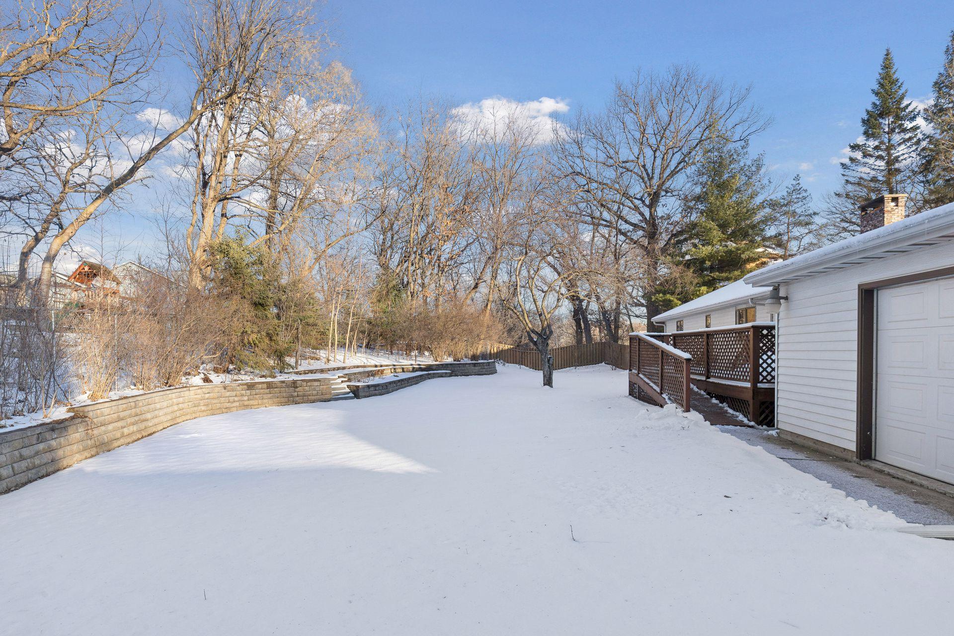 Beautiful level backyard with retaining walls: lower level has three Rosa Ragusa, hydrangeas, Star gazer lilies, daisies, peonies and mint. The upper level has peonies, lilies, and sedum.