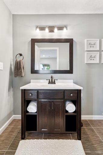 Lower level 3/4 bath with upgraded tile flooring, cool vanity and light and large shower.