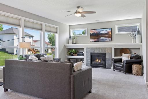 Family room offers ceiling fan/light, abundant windows with custom shades, handsome fireplace wall with custom built-ins, large mantel shelf and transom windows too. Recessed lighting above fireplace wall as well.