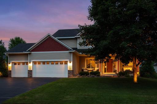 Dusk view showing uplight accenting the mature hardwood tree.