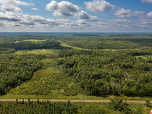 An aerial shot of the property overlooking the road with the property beyond. This is a 20 acre parcel that runs E/W, then leads to 80 acres to the west of the 20 acre parcel on the road.