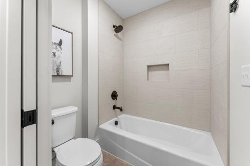 The full bathroom features a double vanity and a combination tub/shower with tile surround.