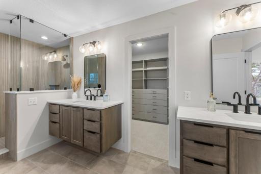 Two separate floating vanities add storage and function.