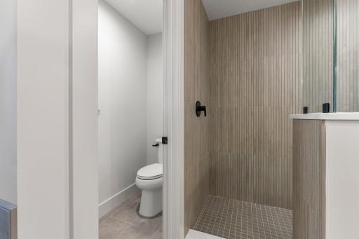 It offers a tiled walk-in shower and beautiful tile flooring.