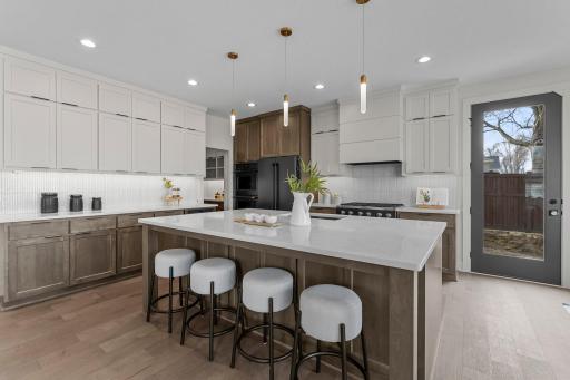 Additional highlights include matte black CafÃ© appliances and a spacious center island with storage and breakfast bar seating.
