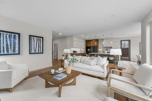The living room is both cozy and sophisticated, anchored by durable wood flooring and expansive windows.