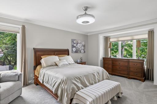 The main level primary suite captures tranquil lake views.