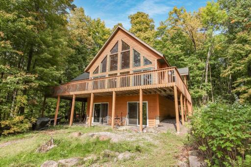 A stunning wall of windows frames your view—Hayward, Wisconsin is calling! Welcome to this Northwoods waterfront retreat, perfectly tucked away on 2.5+ wooded acres