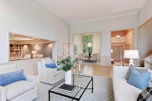 An open, light-filled layout where the living room seamlessly connects to the home office and formal dining area