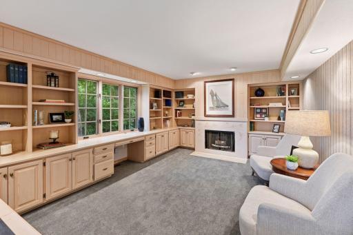 Formal den with fireplace and abundant built-in cabinetry, located just off the living room