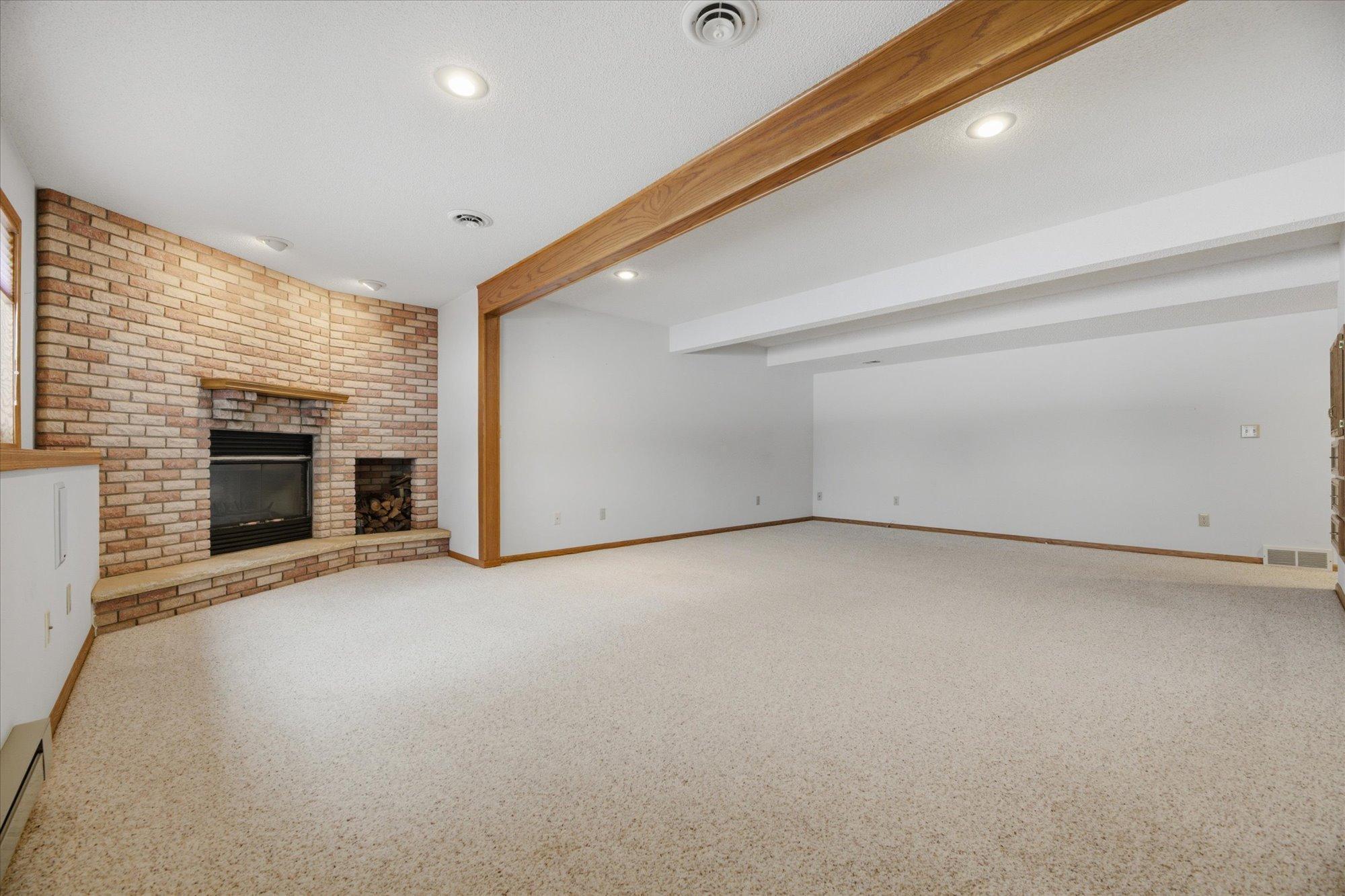 Lower-level living/recreation room (23'x25') with functional fireplace.