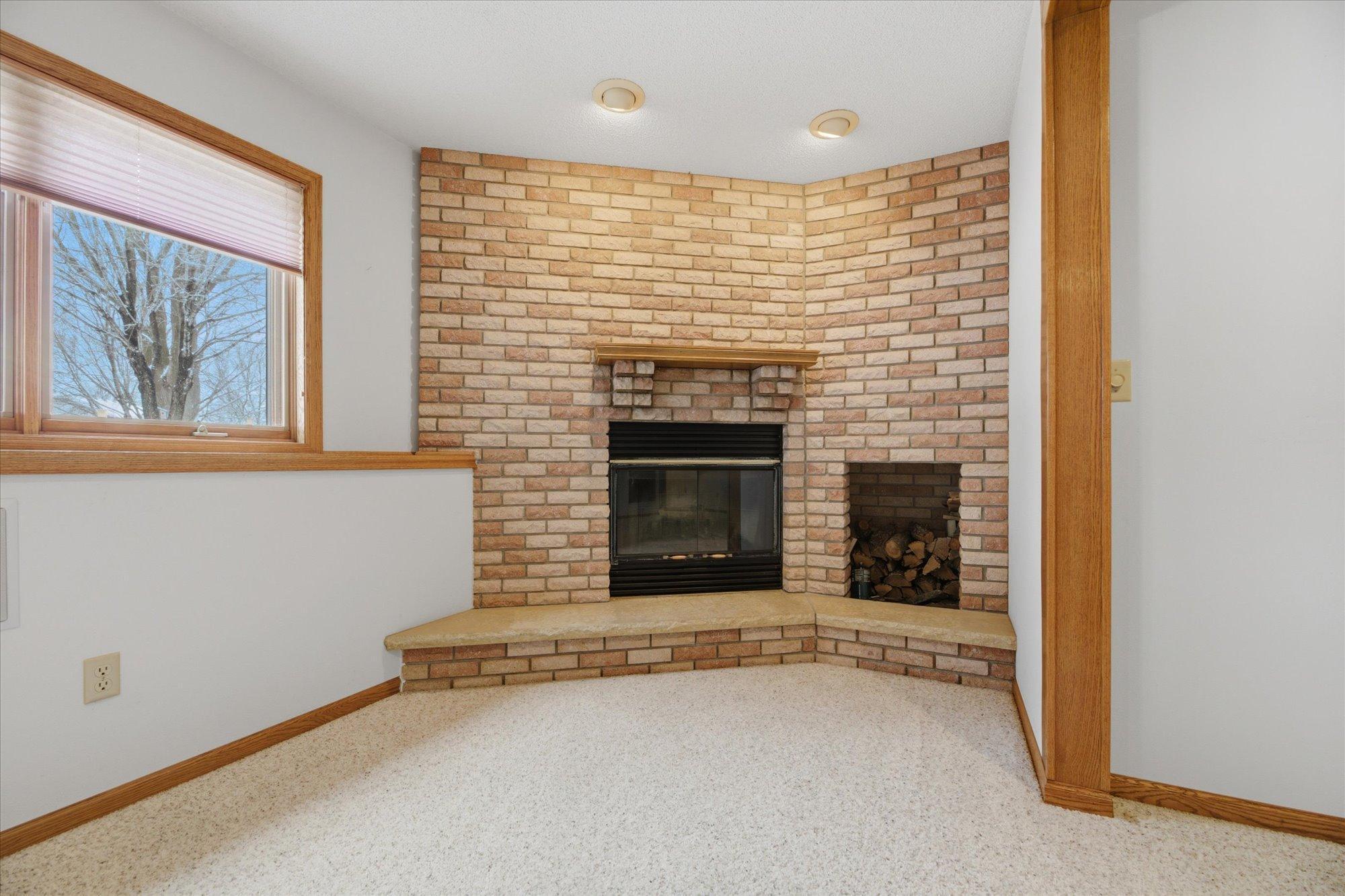 Gas-burning fireplace with brick surround is a beautiful anchor to this large rec-room.