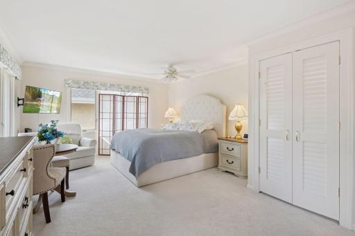 large primary suite bedroom with walk-in closet and stackable laundry , new carpet