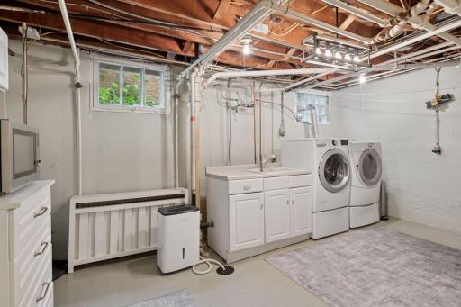 Lower level laundry with wash tub, epoxy floors, storage and workshop