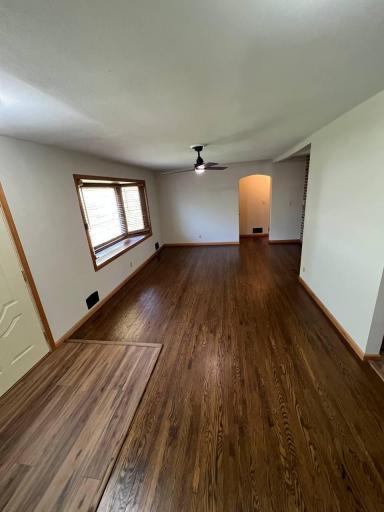 Spacious living room with bow window and refinished hardwood floors