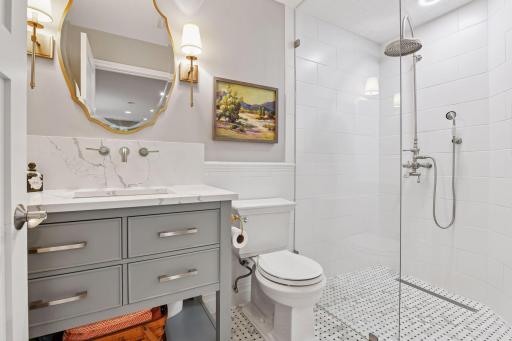 Updated lower-level bath with walk-in shower, custom vanity, and timeless finishes