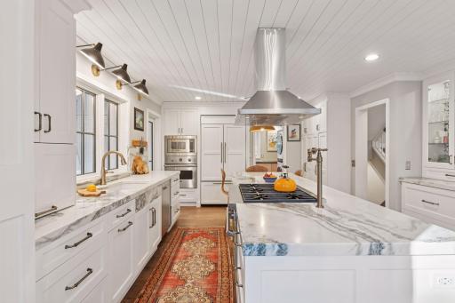 Chefâs kitchen with oversized marble island, custom cabinetry, and premium stainless appliances