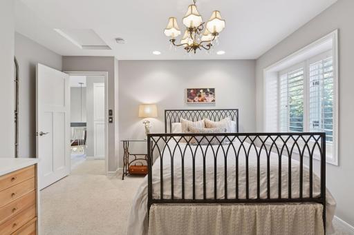 Bright upper-level bedroom with classic details and peaceful tree-lined views