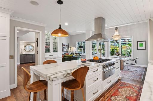 Spacious kitchen with marble island seating, professional range, and clear views into the living areas