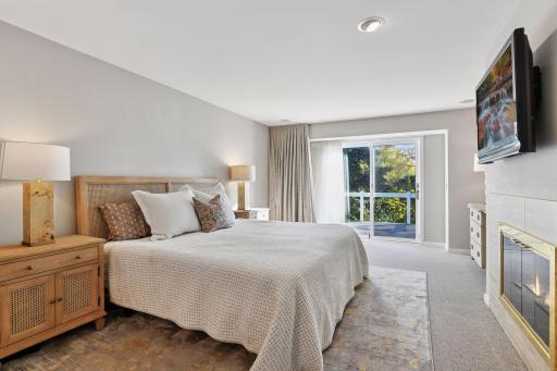 Main-level primary suite featuring a cozy fireplace and private outdoor access