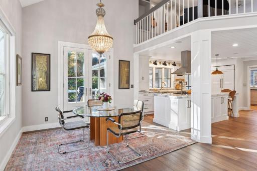 Elegant dining area with statement chandelier adjacent to the open kitchen