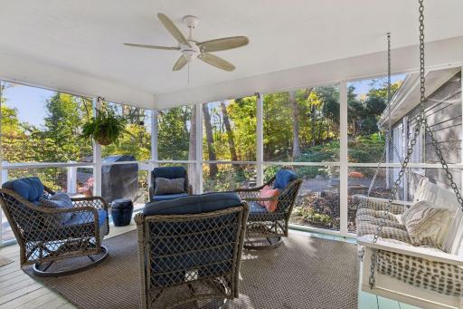 Inviting screened porch with charming porch swing, wooded views, and space for relaxed outdoor living