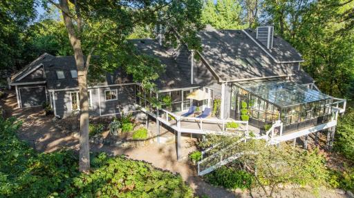 Elevated deck and screened porch nestled among mature trees and lush landscaping