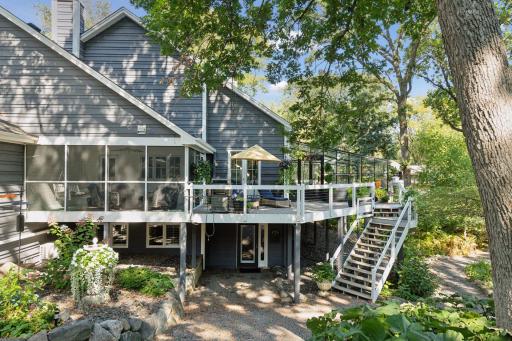 Expansive deck with screened porch and stairs to the landscaped yard below
