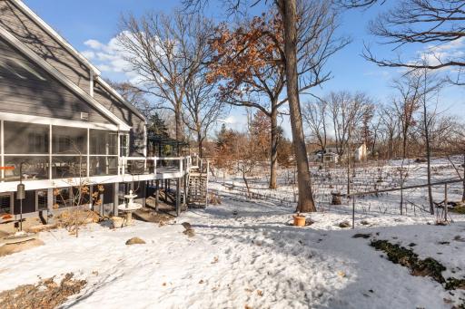 Private backyard with wooded views, multiple outdoor living areas, and year-round natural beauty