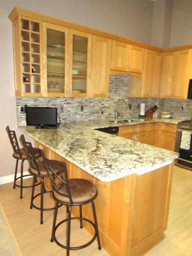 Wine rack, lighted cabinet and appliance plug-ins at the end of the breakfast bar.