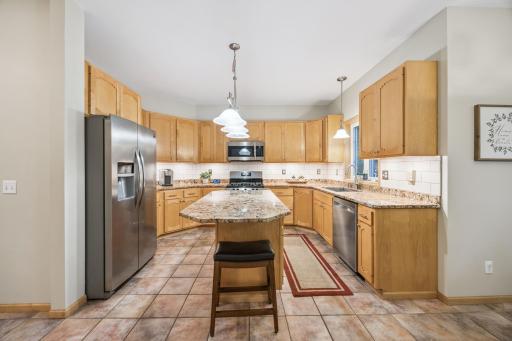 The updated kitchen boasts granite countertops, a tile backsplash, and stainless steel appliances.