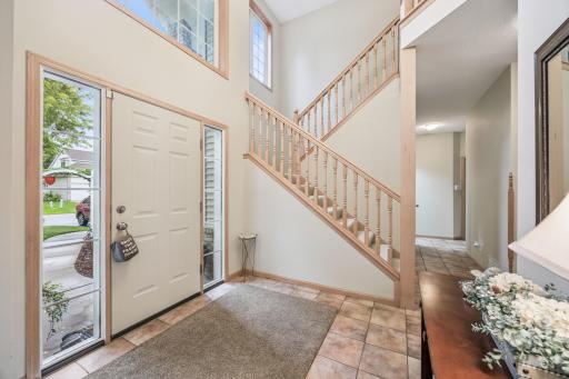 The foyer is filled with natural light and showcases tile flooring and light wood accents.
