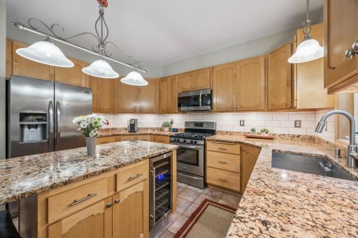 Maple cabinetry offers generous storage, complemented by a convenient beverage and wine fridge integrated into the island.