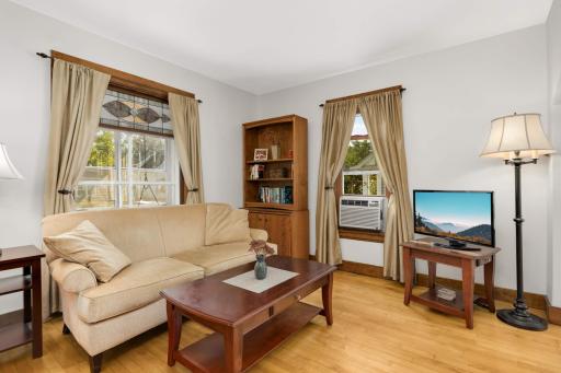 The comfortable living room is light and bright with 2 large windows looking out to the porch. The lovely stained glass window is a focal point.