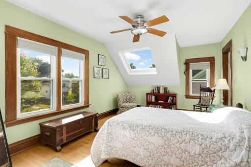 The serene primary bedroom features east-facing views, mellow hardwood floors, a ceiling fan and new skylight window for star-gazing.