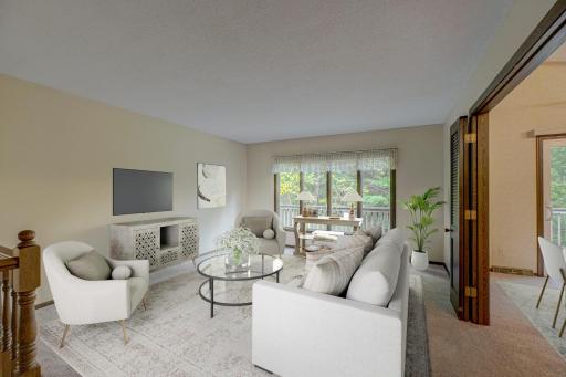 This cozy living room with new carpet, located just off the dining area, creates an inviting space thatâs perfect for entertaining