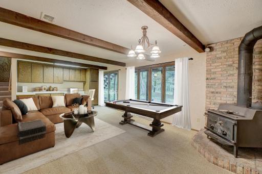 The lower-level walkout family room provides plenty of space for entertaining, highlighted by a charming wood stove for cozy gatherings