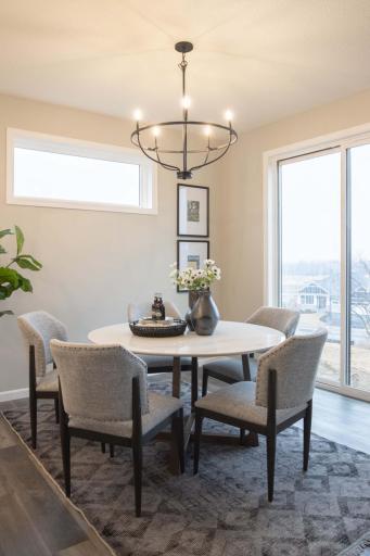 This bright & inviting dining space is a true standout, featuring an elevated transom window that floods the room w/ natural light, creating a warm and airy atmosphere. The 8-foot sliding glass is a show stopper demonstrating the attention to detail.