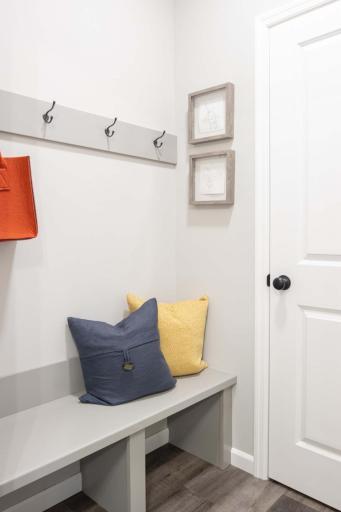 Whether you’re coming in from the garage or backyard, this mudroom creates an organized entryway, helping to keep your home clutter-free with the built in bench and hooks. Photos are from previously built home; options and features may vary.