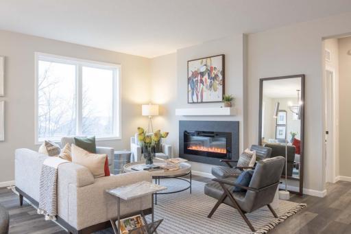 The heart of this home is the cozy family room, designed for both comfort and relaxation. Featuring a modern electric fireplace, it provides a warm and inviting atmosphere. Photos are from previously built home; options and features may vary.